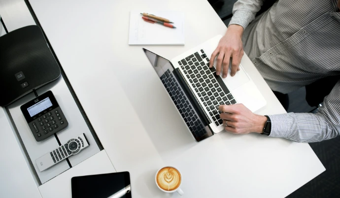 person using laptop on white wooden table